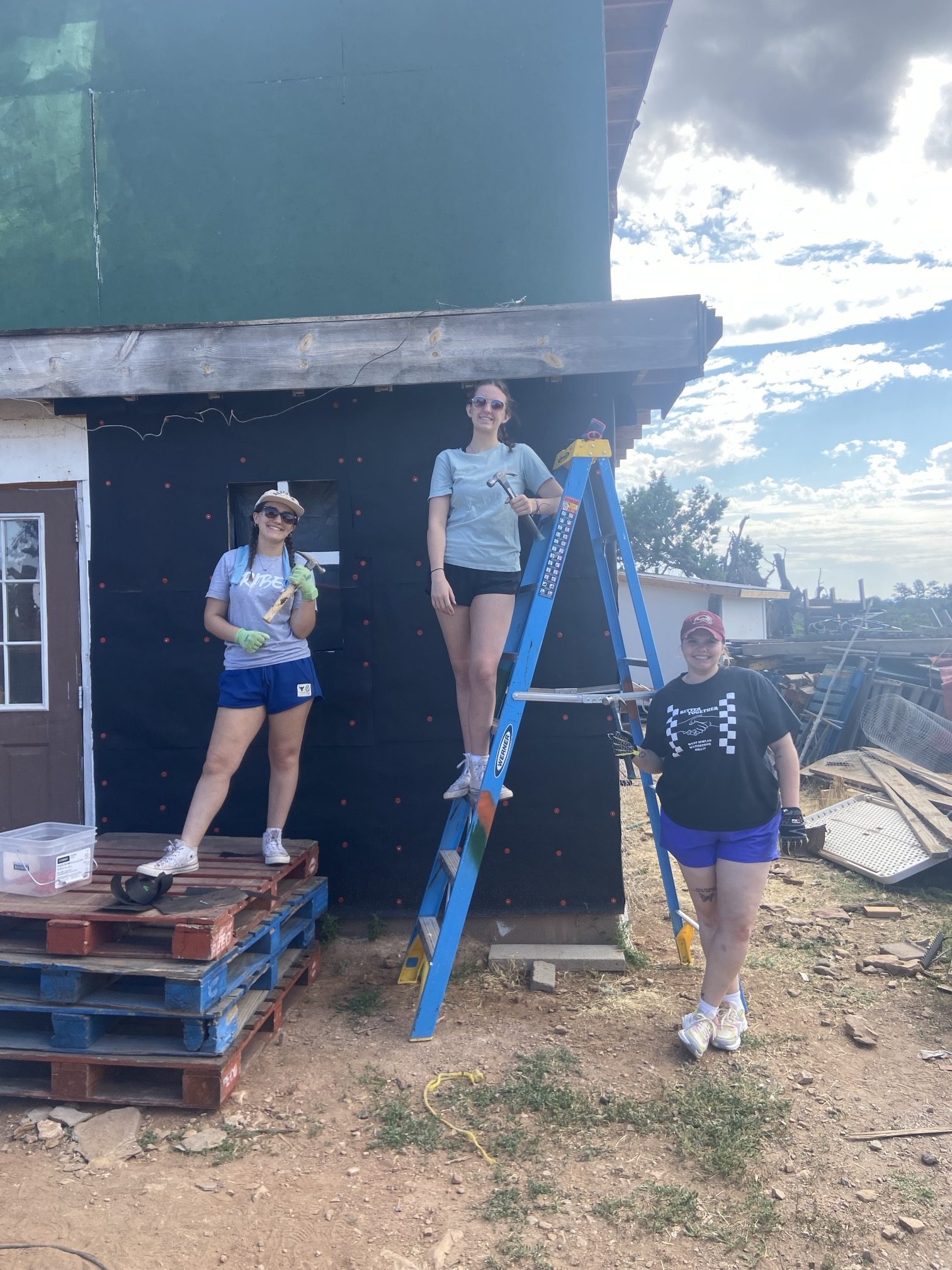 three young women repairing a building