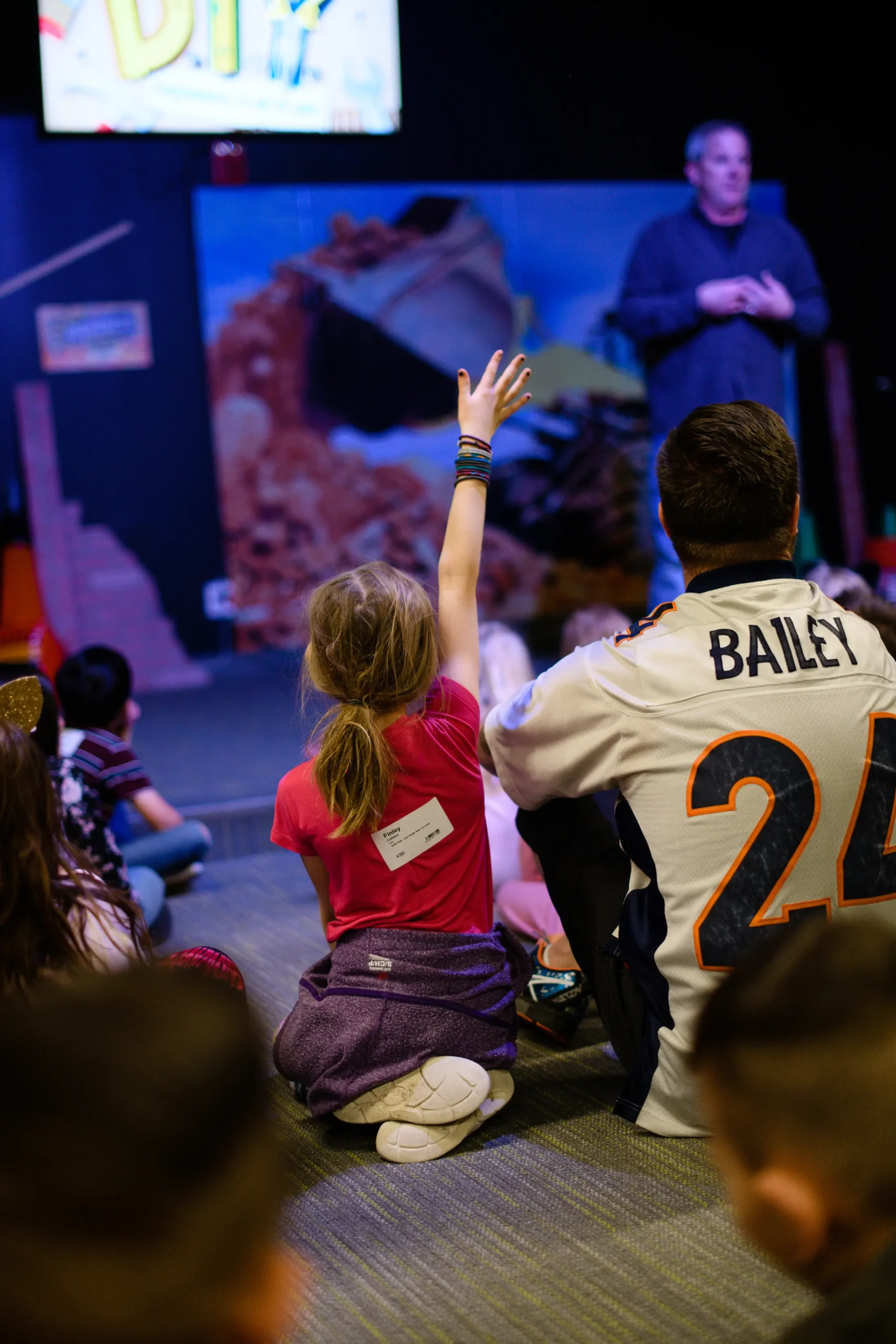 a girl with her arm raised during a kids service