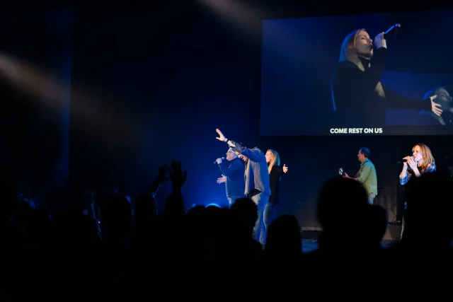 a worship leader with his hand raised during a worship service