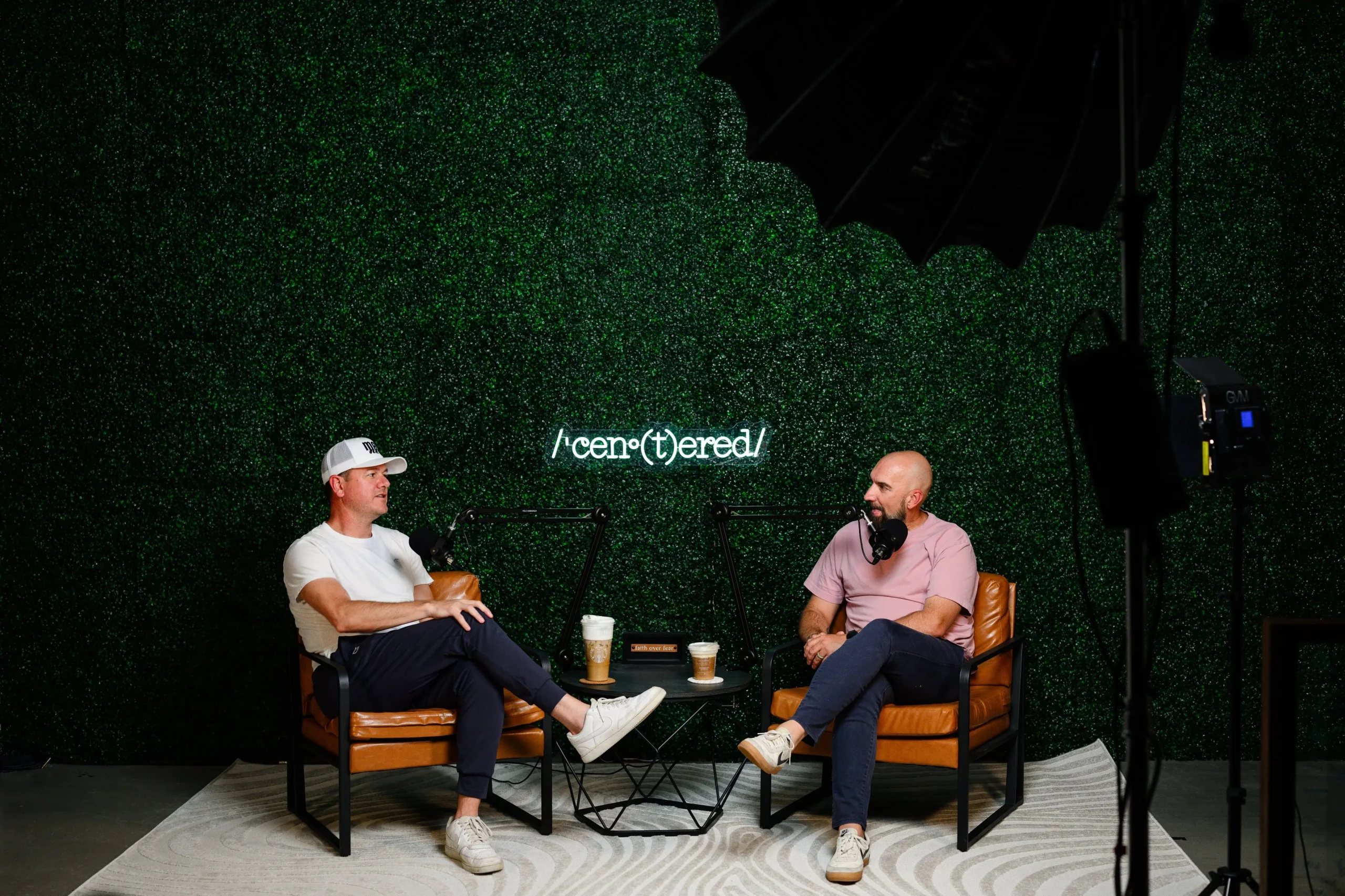two men sitting in chairs before recording a podcast