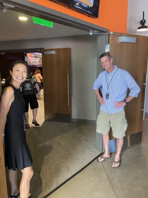 two greeters holding open doors to the church