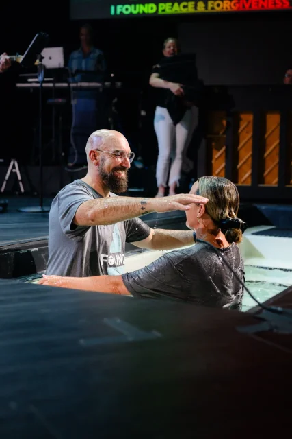 a pastor hugging a woman after baptizing her