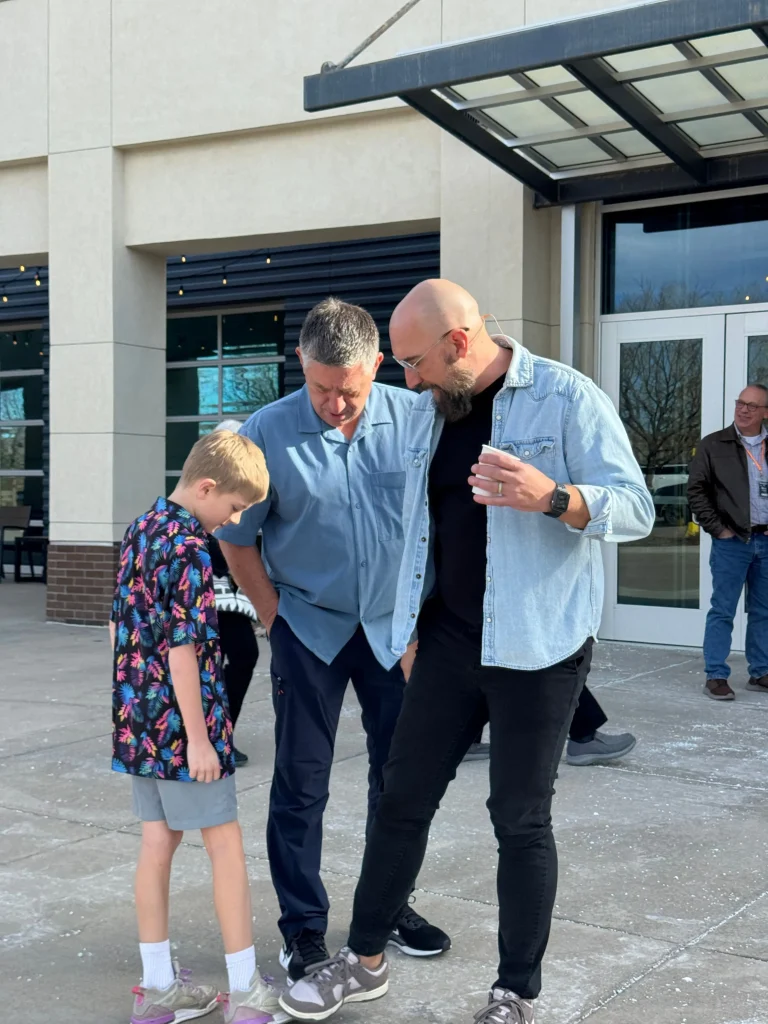 a pastor greeting a man and young boy