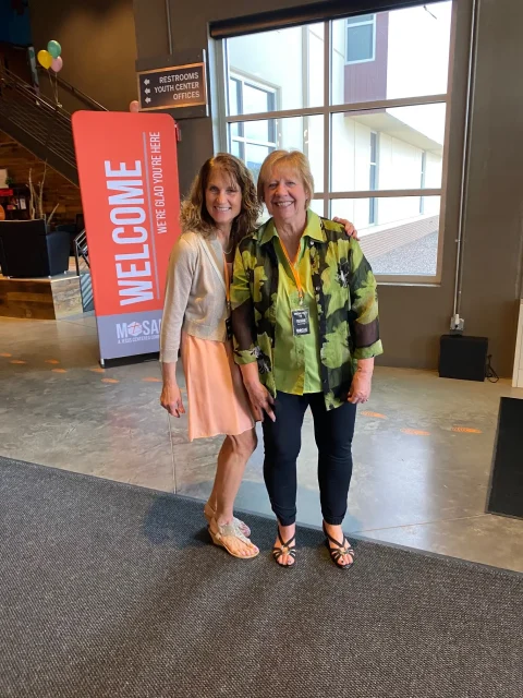 two women pose in a church lobby
