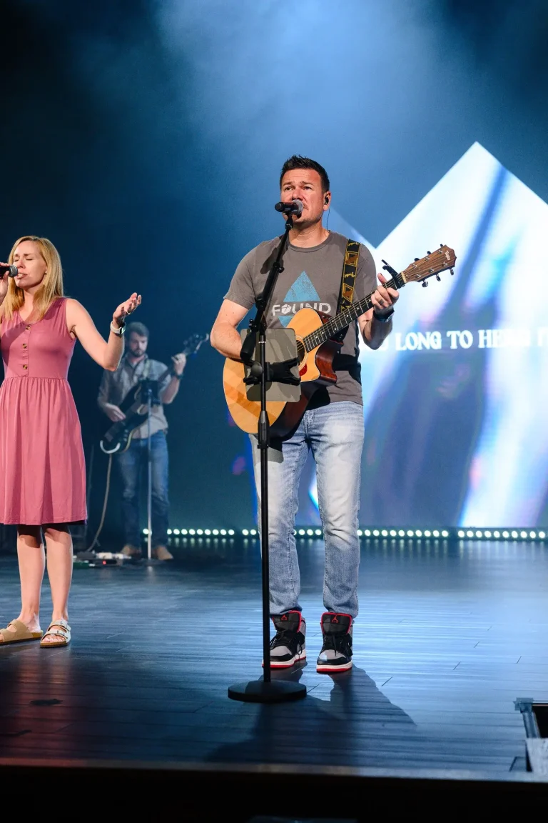 a worship leader singing and playing guitar