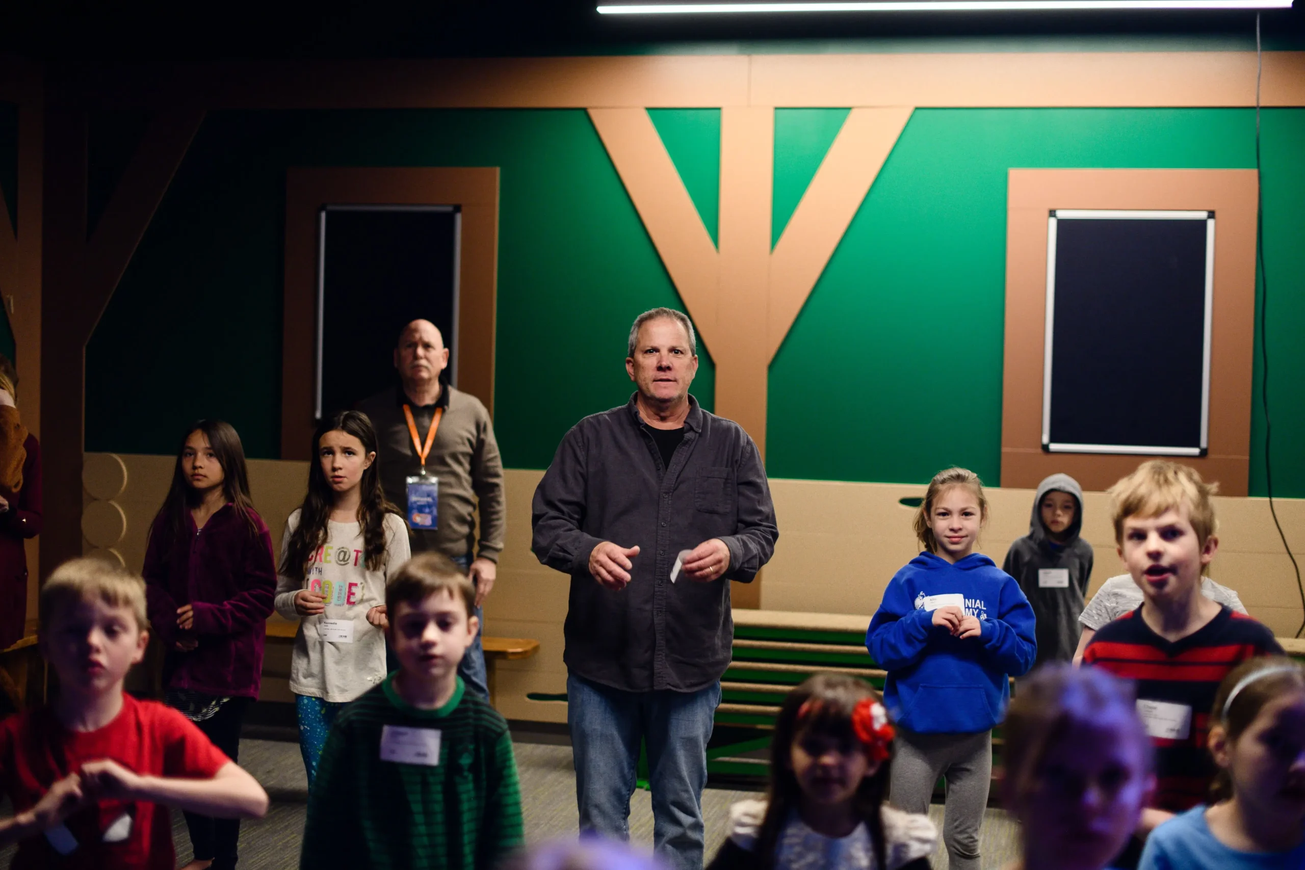 an adult leader with kids doing hand motions during a song