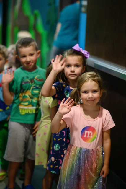 a group of kids waving at the camera