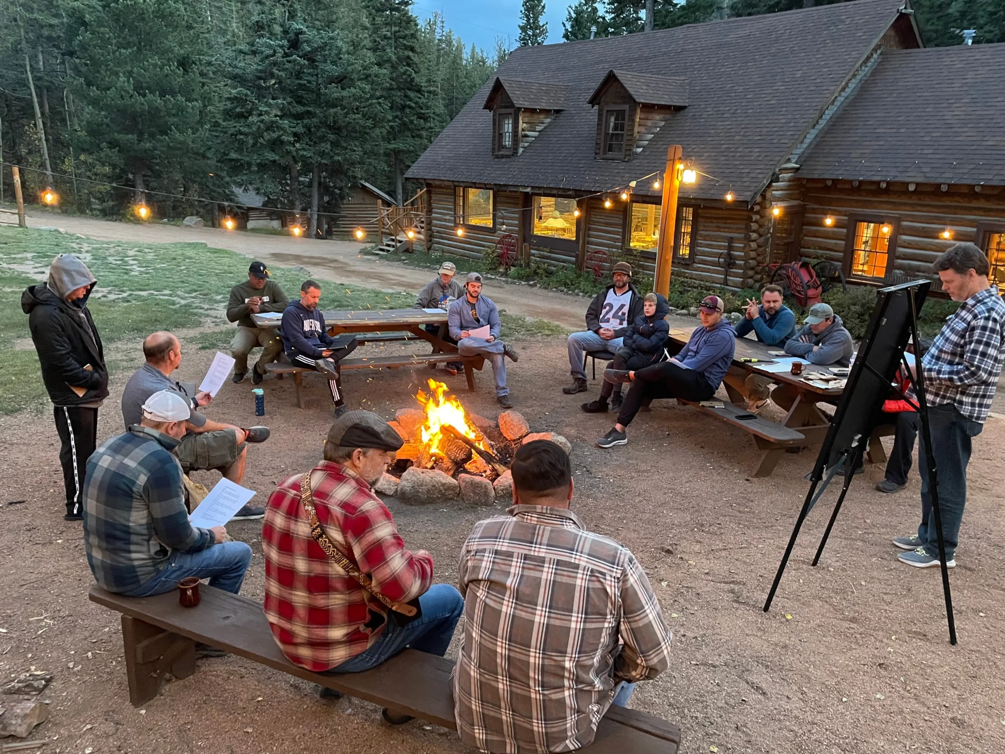 a large group of men gathered around a fire pit